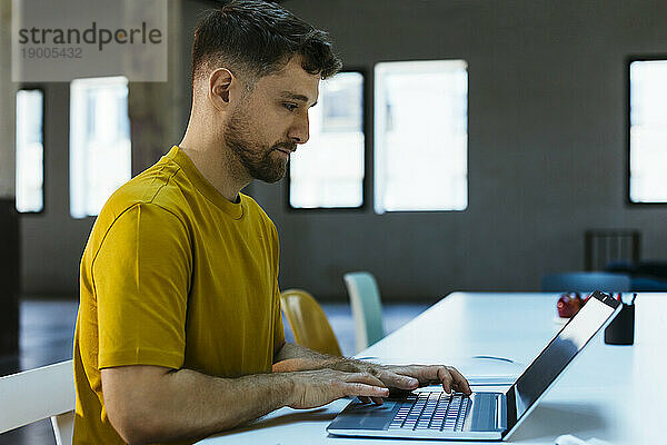 Geschäftsmann arbeitet am Laptop am Schreibtisch