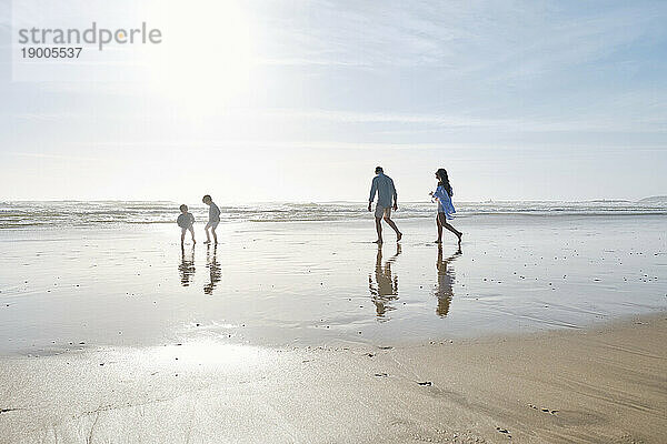 Family enjoying together at beach on sunny day