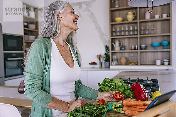 Lächelnde Frau  die zu Hause in der Küche Essen zubereitet