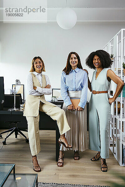 Team glücklicher Geschäftsfrauen am Schreibtisch im Büro