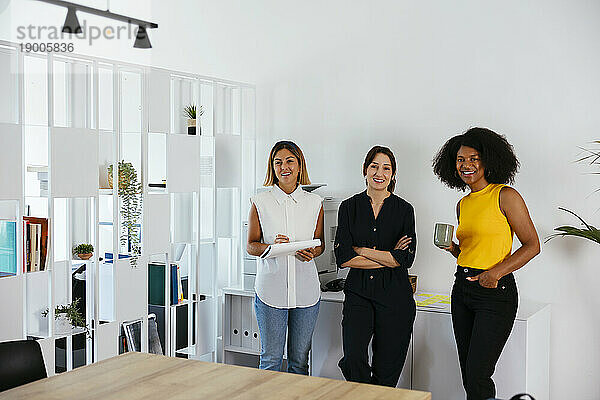 Team glücklicher Geschäftsfrauen  die im Kreativbüro stehen