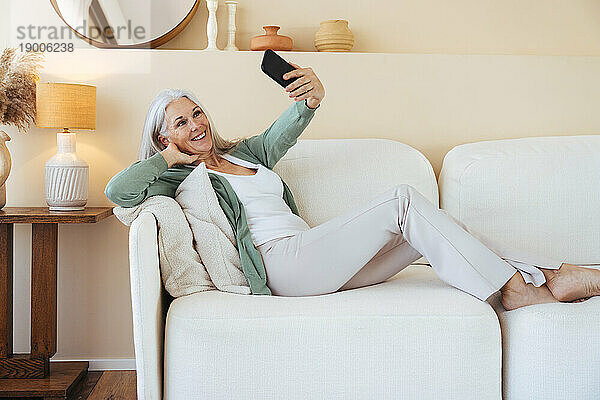 Glückliche reife Frau  die zu Hause ein Selfie mit dem Handy macht