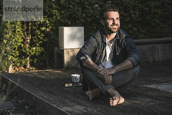 Nachdenklicher Mann sitzt auf der Veranda