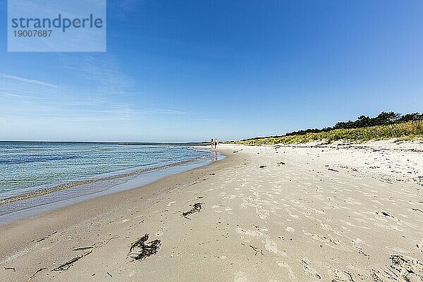 Zwei Teenager an einem leeren Strand im Sommer