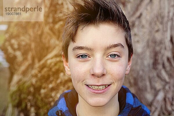 Porträt eines lächelnden Teenagers mit blau karierter Holzfällerjacke