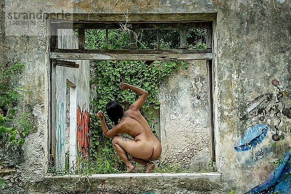 Ein wunderschönes nacktes Latino Modell posiert in einem verlassenen Pueblo in der mexikanischen Provinz Yucatan