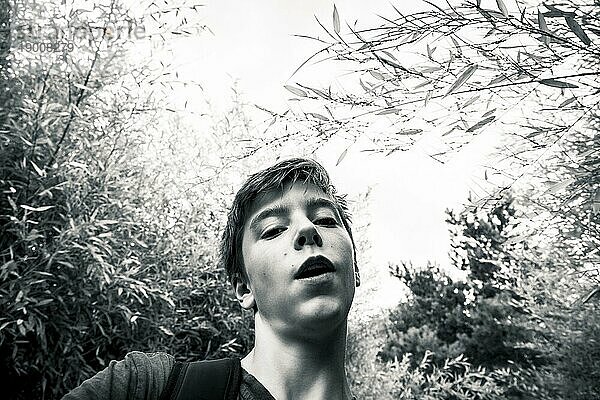Schwarzweißaufnahme eines Teenagers in einem Garten