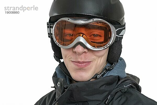 Lächelnder junger Mann mit Skihelm und Skibrille  vor weißem Hintergrund