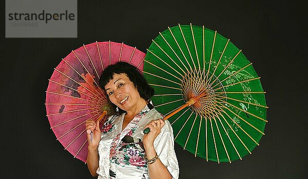Asiatischer Tanz mit Schirmen