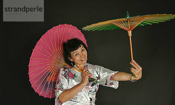 Asiatischer Tanz mit Schirmen