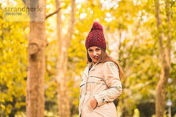 Porträt einer Frau im Herbst neben einem Wald in der Natur