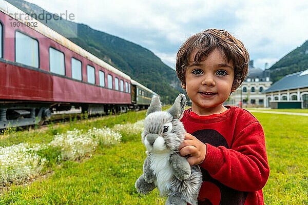 Ein Kind mit einem Stofftier hat Spaß im alten Bahnhof von Canfranc in den Pyrenäen. Spanien