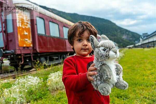 Ein Kind mit einem Stofftier hat Spaß im alten Bahnhof von Canfranc in den Pyrenäen. Spanien