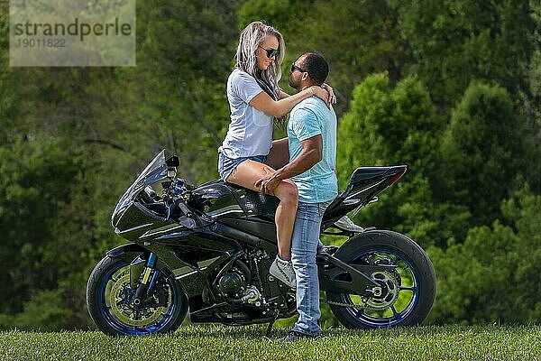 Ein gemischtrassiges Paar genießt einen Sommertag auf dem Motorrad