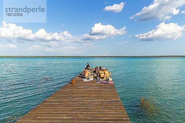 Menschen sitzen auf einem Holzsteg am Wasser  Bacalar See  Bacalar  Quintana Roo  Halbinsel Yucatan  Mexiko  Mittelamerika