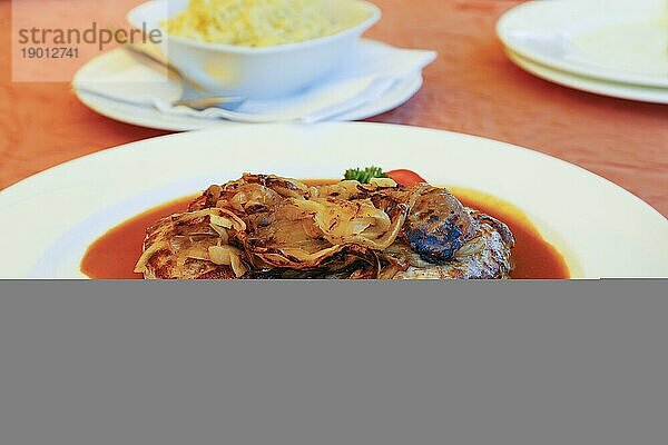 Schwäbische Küche  Zwiebelrostbraten  angebratene Zwiebeln  gebratener Rostbraten mit gerösteten Zwiebeln  Roastbeef  Rindfleisch  traditionelles Hauptgericht  deftig  Soße  Sauce  typisch Schwäbisch  deftige Hausmannskost  Teller  Traditionsküche  Foodfotografie  Studio  Deutschland  Europa