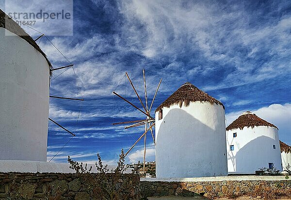 Berühmte Touristenattraktion von Mykonos  Kykladen  Griechenland. Drei traditionelle  weiß getünchte Windmühlen am Wasser und in der Stadt Chora. Sommer  blauer Himmel  schöne Wolken. Reiseziel  ikonische Ansicht. Rückansicht