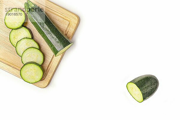 Zucchini (Cucurbita pepo)  aufgeschnitten  auf Holzbrett  auf weiß  Kopierraum