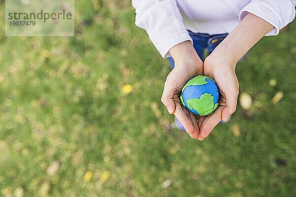 Erhöhte Ansicht kleinen Ton Globus geschröpft Hände Gras. Auflösung und hohe Qualität schönes Foto