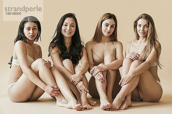 Gruppe attraktive junge Frauen Unterwäsche sitzen Studio