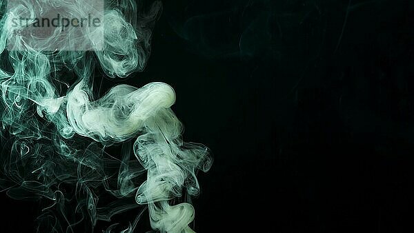 Abstrakter grüner Rauch bewegt schwarzen Hintergrund. Schönes Foto