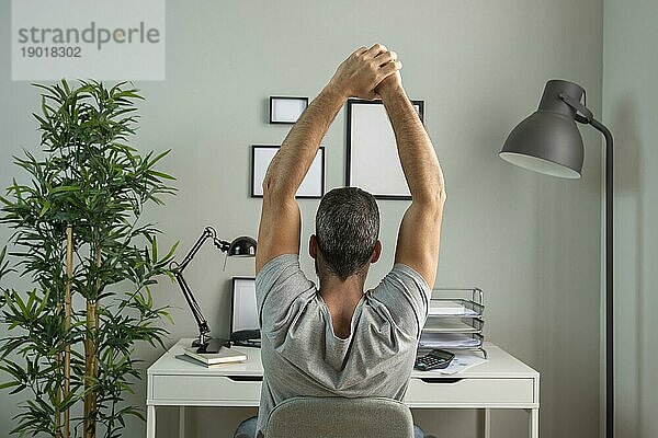 Rückenansicht Mann Schreibtisch Stretching während der Arbeit von zu Hause. Auflösung und hohe Qualität schönes Foto