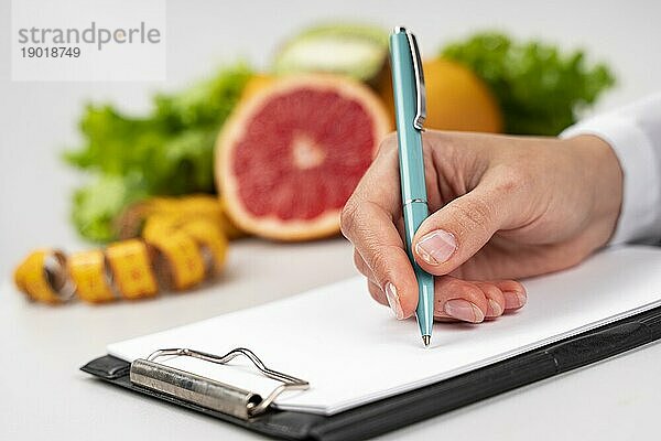 Frau schreibt verschwommenes Obst. Schönes Foto