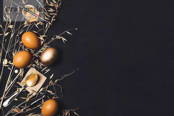 Ostereier in der Nähe von Löffel Papier Pinsel Farbstoff kann trockenes Gras. Foto mit hoher Auflösung