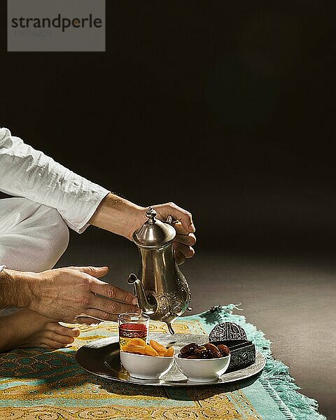 Mann weiß gießt Tee kleine Tasse Vorderansicht. Auflösung und hohe Qualität schönes Foto