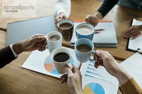 Hohe Winkel Menschen jubeln mit Kaffeebecher während Büro Sitzung. Foto mit hoher Auflösung