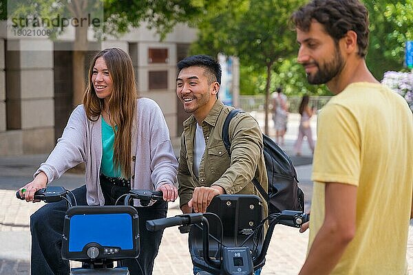 Gruppe multiethnischer Freunde in der Stadt  die sich neben Leihfahrrädern treffen