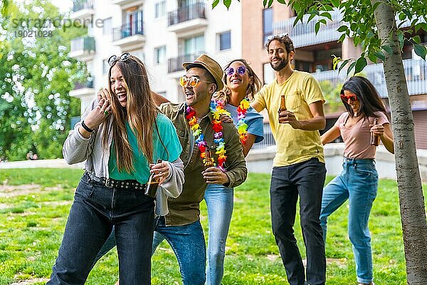 Eine Gruppe multiethnischer Freunde bei einer Geburtstagsfeier im Stadtpark tanzt  Sommervergnügen zwischen Klassenkameraden und Freunden