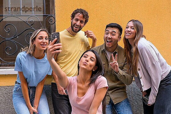 Gruppe gemischtrassiger Freunde  die in der Stadt ein lächelndes Selfie machen