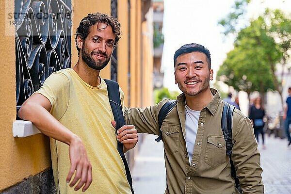Porträt von zwei multiethnischen männlichen College Freunden in der Stadt  die lächelnd einen Asiaten und einen Kaukasier zeigen