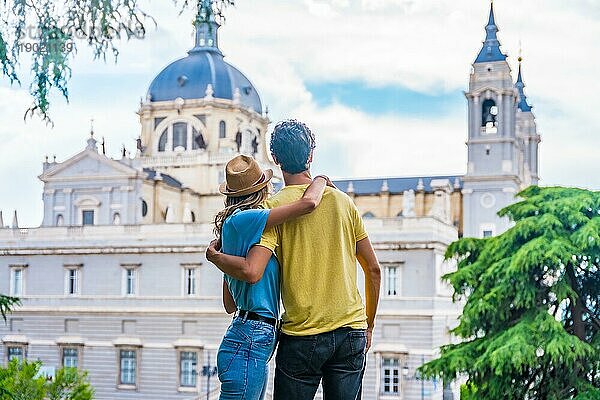 Touristisches Paar  das die Stadt Madrid im Sommerurlaub besucht. Urlaubskonzept für Reisende  mit Blick auf die Almudena im Rücken