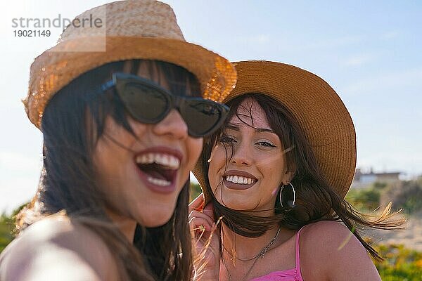 Nahaufnahme von Frauen Freunde mit Hut im Urlaub am Strand nehmen ein Selfie mit dem Telefon lächelnd