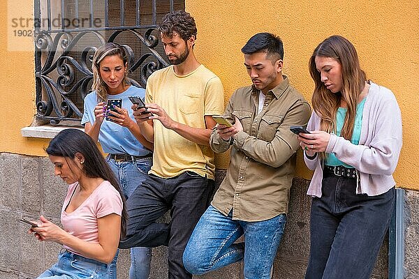 Gruppe von multirassischen Freunden  die in der Stadt ernsthaft auf das Telefon schauen  Konzept der Jugend  die süchtig nach dem Handy ist