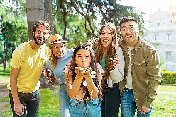 Porträt multiethnische Gruppe feiern werfen Konfetti im Park  Spaß mit Freunden Konzept