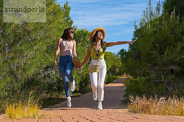 Weibliche Freunde haben Spaß im Urlaub in einem Park im Sommer zu Fuß auf einem Weg