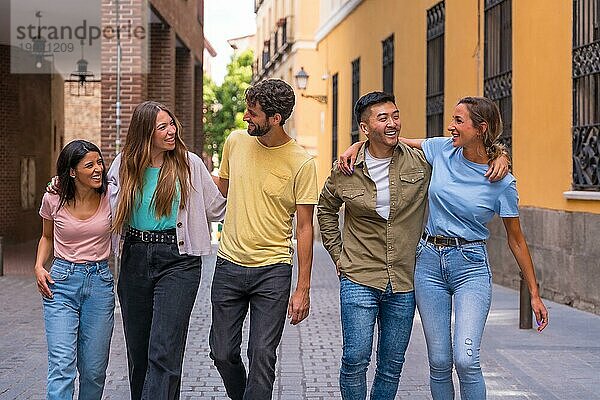 Gruppe von multirassischen Freunden  die sich lächelnd in der Stadt umarmen  Freundschaftskonzept mit Jungs und Mädchen  die in der Straße der Stadt abhängen