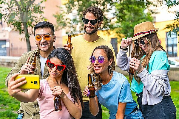 Multiethnische Gruppe von Freunden  die im Stadtpark feiern und ein Selfie machen  Freundschaft und Spaßkonzept mit Sonnenbrille und Bier trinken