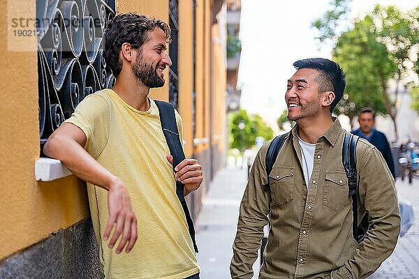 Zwei multiethnische männliche College Freunde in der Stadt lächeln  ein Asiate und ein Weißer