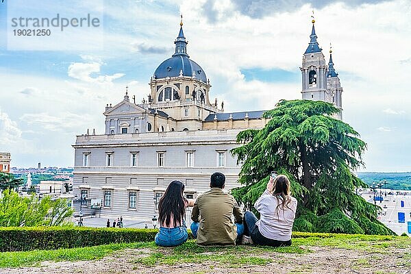 Touristenfreunde  die im Sommerurlaub die Stadt Madrid besuchen. Sitzen mit Blick auf die Almudena