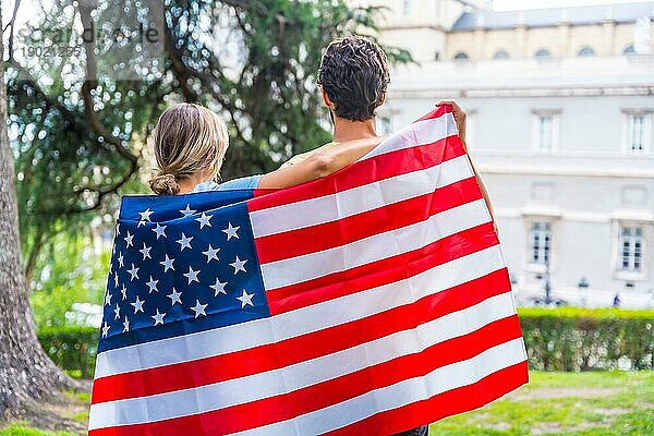 Ehepaar in der Stadt mit usa Flagge  Junge und Mädchen auf dem Rücken. Patrioten stolz auf ihre Nation  Unabhängigkeitstag