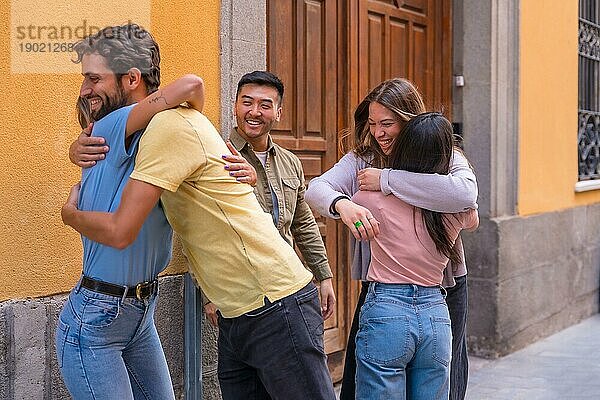 Gruppe von multirassischen Freunden  die sich in der Stadt begrüßen und küssen  Freundschaftskonzept mit Jungen und Mädchen