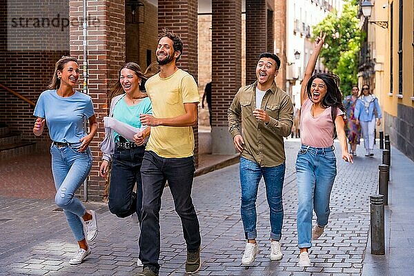 Gruppe von multirassischen Freunden  die sich umarmen  lächeln und in der Stadt springen  Freundschaftskonzept mit Jungen und Mädchen