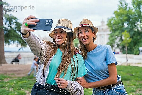 Zwei Freundinnen in der Stadt lächelnd und mit Spaß machen ein Selfie mit dem Telefon