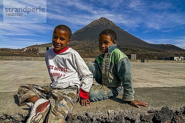 Lächelnde  glückliche Jungen vor einem Vulkan auf Fogo. Cabo Verde. Afrika