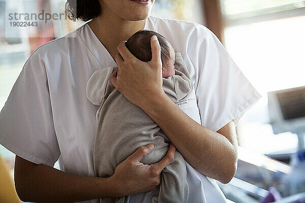 Melden Sie sich bei der Neugeborenenabteilung der Stufe 2 eines Krankenhauses in Haute-Savoie. Eine Krankenschwester kümmert sich um ein Kleinkind.