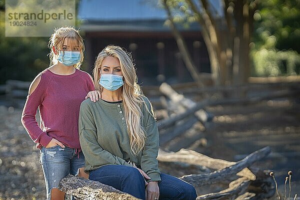 Eine Mutter und ihre Tochter genießen einen Tag im Freien  während sie während der Covid 19 Pandemie Masken tragen und einen Sicherheitsabstand zu anderen Menschen einhalten